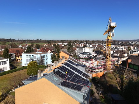 Techniker bei der Optimierung und Wartung einer PV-Anlage auf einem Wohngebäude in der Schweiz